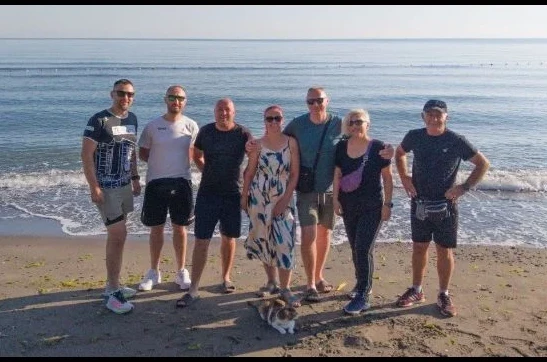 Grupa ljudi i mačka na plaži