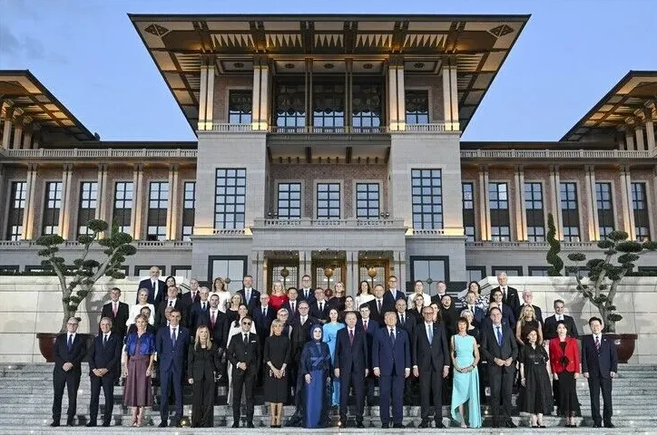 Grupna fotografija zvaničnika iz raznih zemalja okupljenih ispred impozantne zgrade sa stepeništem.
