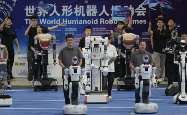 Grupa ljudi i humanoidni roboti na takmičenju