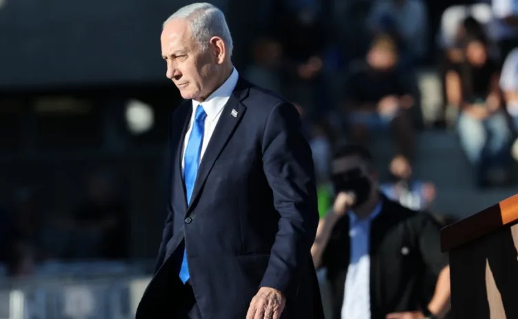 Portret izraelskog političara Bendžamina Netanyahua, koji nosi tamno odijelo i plavu kravatu.