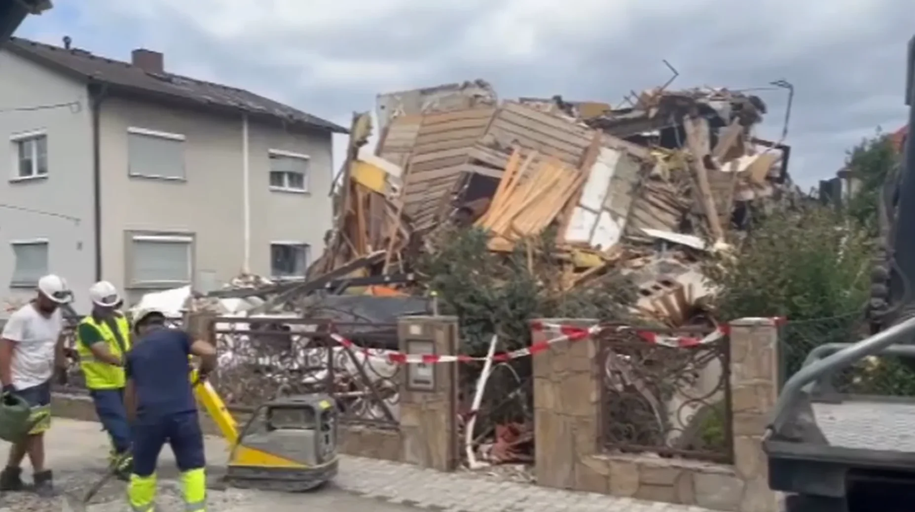 Građevinski radnici u zaštitnoj opremi vrše sanaciju nakon što se urušio dio stambenog objekta.