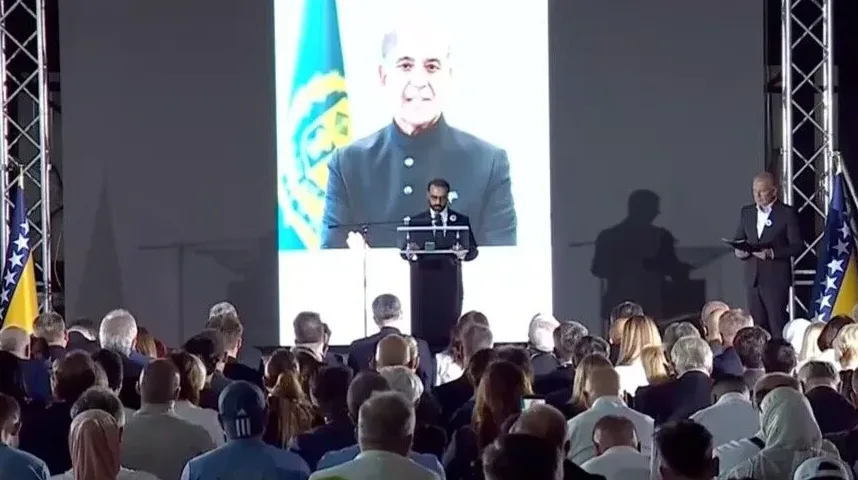 Politički govor ispred velikog ekrana sa slikom govornika i zastavom Bosne i Hercegovine.