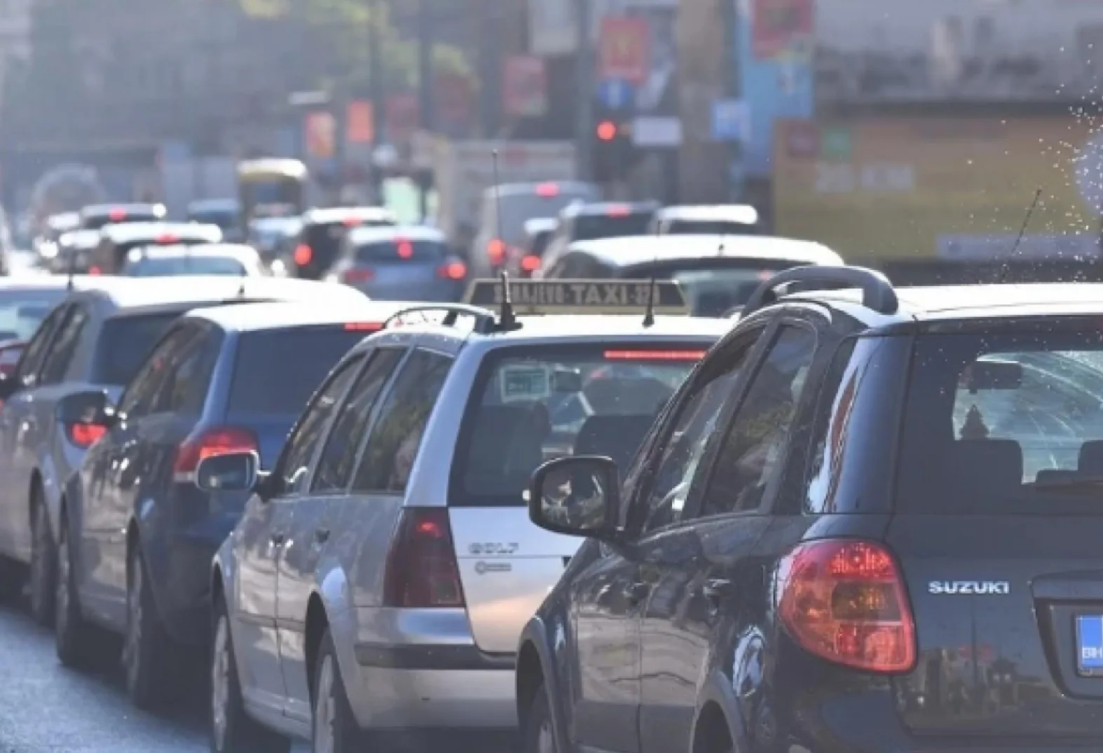Saobraćajna gužva sa više automobila u koloni, uključujući i taksi vozilo.