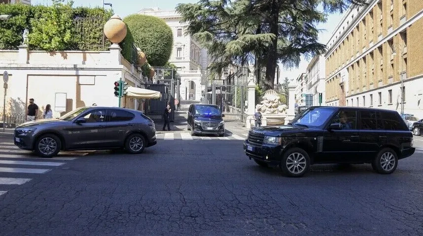 Crni džip marke Range Rover i sivi SUV marke Alfa Romeo voze ulicom u Rimu, u pozadini se vidi zgrada i drveće.