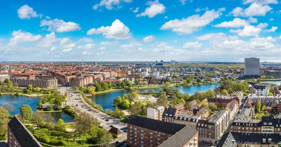 Panoramski pogled na Kopenhagen s jezerom, zelenim parkovima i gradskim kvartovima u proljetni dan.