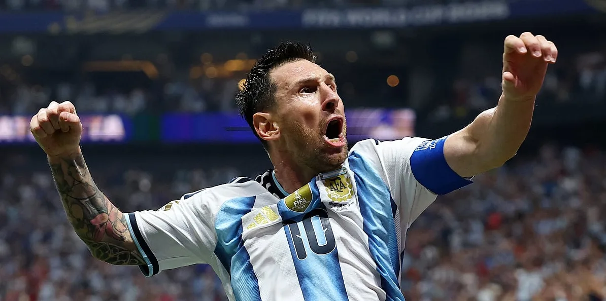 Lionel Messi u dresu Argentine sa podignutim rukama u zrak, slaveći postignuti gol.