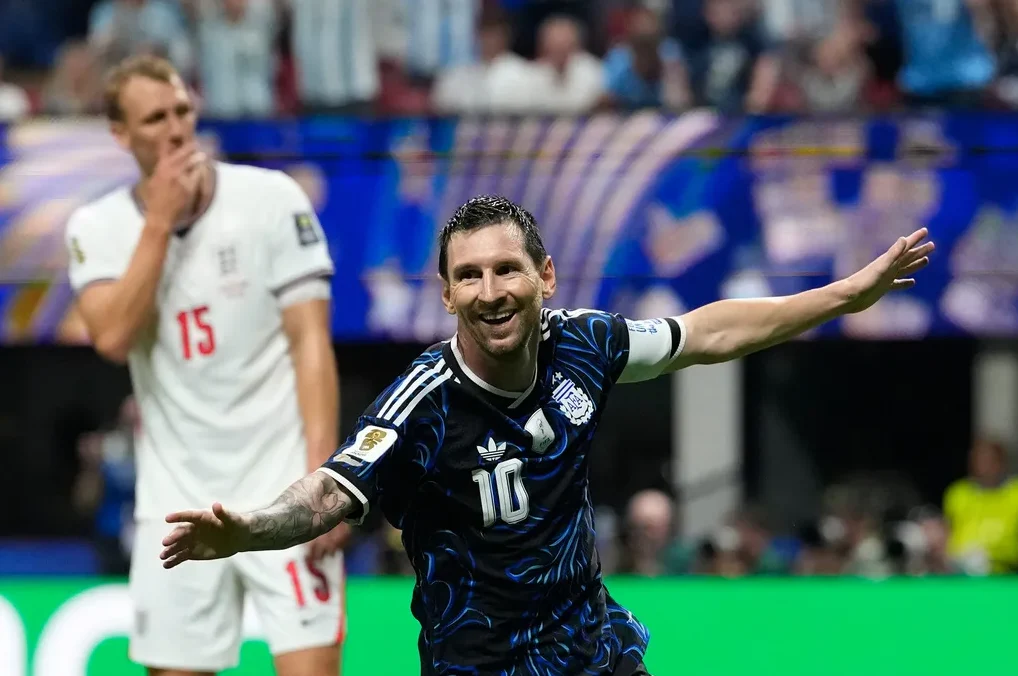 Fudbaler Lionel Mesi u dresu Argentine sa brojem 10 slavi pogodak na utakmici protiv Sjedinjenih Američkih Država, dok je u pozadini vidljiv igrač SAD-a sa brojem 15.
