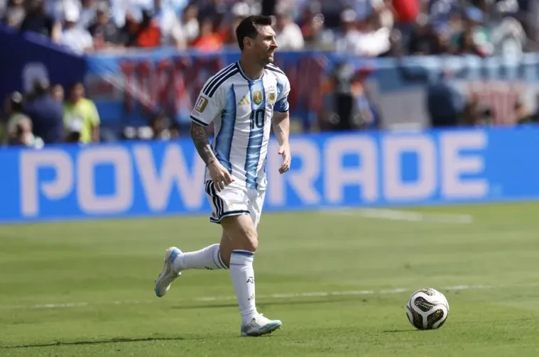 Fudbaler Lionel Messi u dresu Argentine trči s loptom na terenu.
