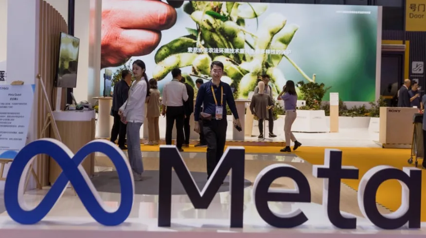 Logotip Meta sa beskonačnom petljom i natpisom "Meta" u prvom planu, te ljudi i izložbeni štandovi u pozadini na sajmu u Kini.