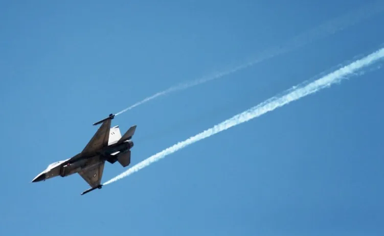 Mlazni lovac F-16 leti kroz bistri plavi nebeski svod, ostavljajući za sobom dva duga, bijela traga pare.