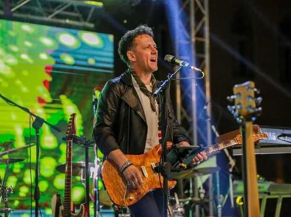 Muzičar svira električnu gitaru na bini tokom koncerta.