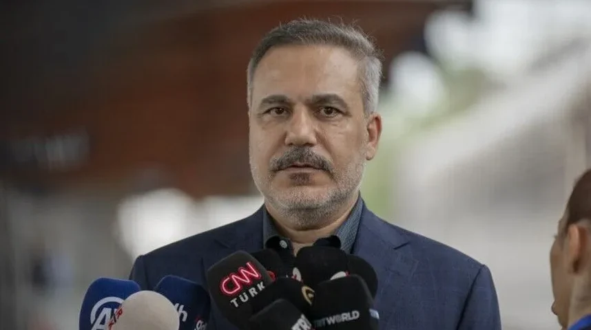 Muskarac sa sijedom kosom i brkovima drži govor ispred novinara sa logotipima CNN Turk, AA i TRT World.