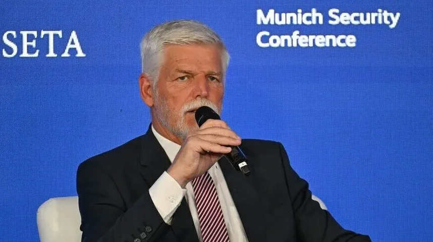 Čovjek sa sijedom kosom i bradom govori u mikrofon na panel diskusiji.