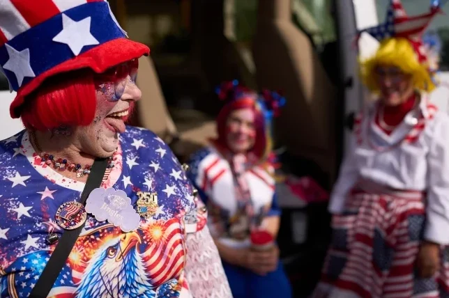 Žena u američkoj zastavi šešir i majicu s likom orla, kao i dvije žene u sličnim kostimima u pozadini.