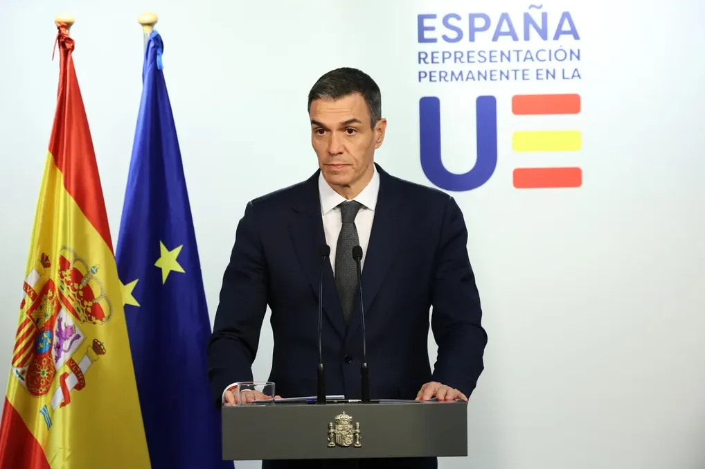 Pedro Sánchez stoji iza govorničke govornice sa španskom i zastavom Evropske unije pored njega.