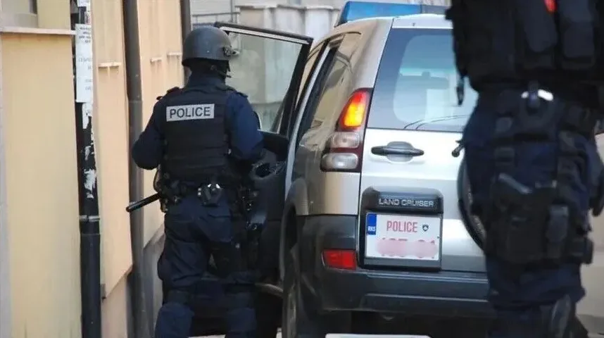 Policajac u punoj opremi izlazi iz policijskog SUV vozila