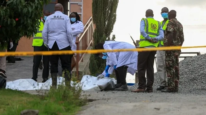 Policijski službenici i forenzičari obavljaju uviđaj na mjestu zločina gdje se nalaze tijela prekrivena bijelim platnom, okruženi žutom policijskom trakom.