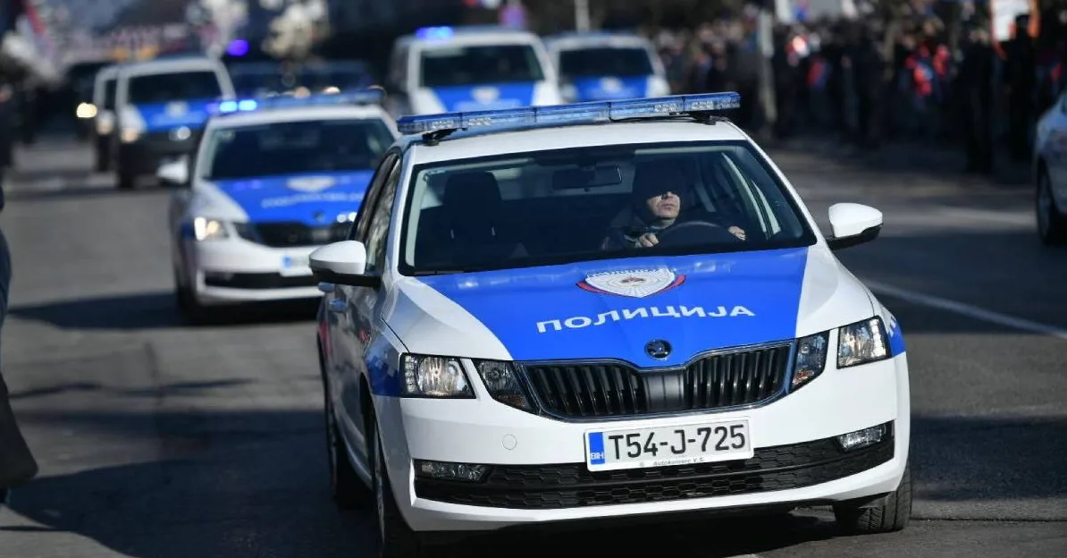 Policijski automobil sa upaljenim plavim rotacionim svjetlima i natpisom "ПОЛИЦИЈА" na prednjoj strani.