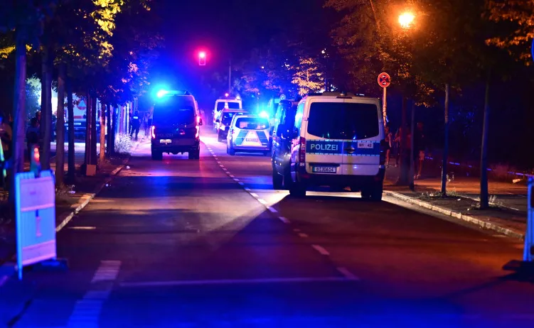 Policijska vozila sa upaljenim rotacijskim svjetlima na ulici noću.