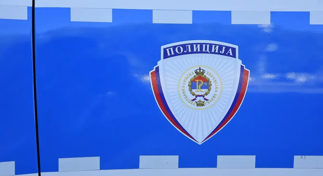 Grb sa natpisom "Policija" i grbom Republike Srpske na plavoj pozadini sa bijelim horizontalnim prugama