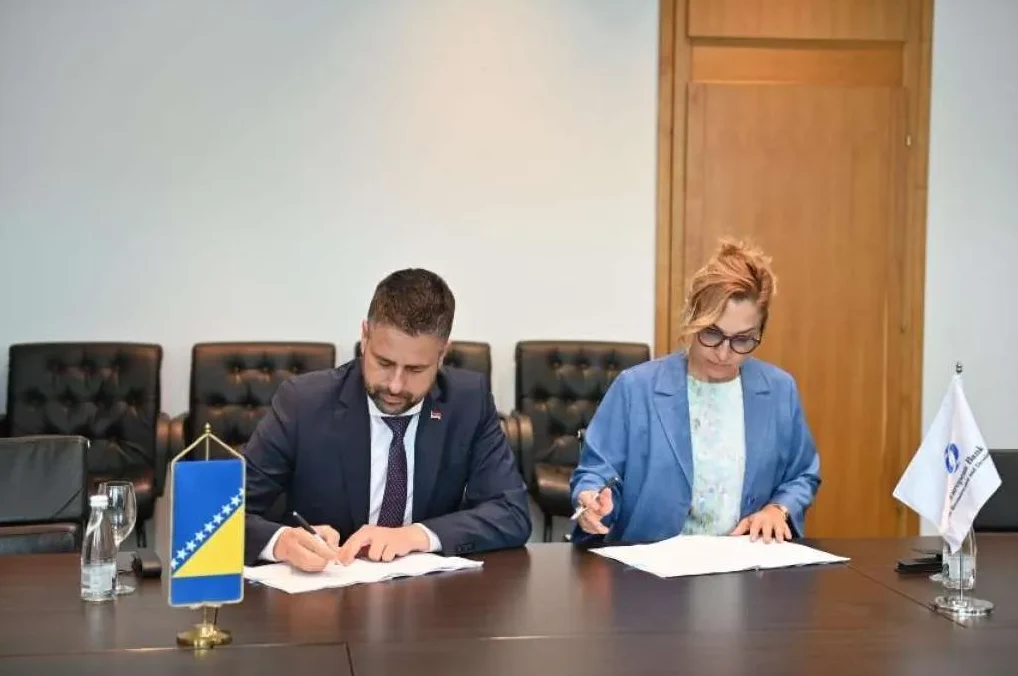Muškarac i žena potpisuju dokumente u kancelariji.
