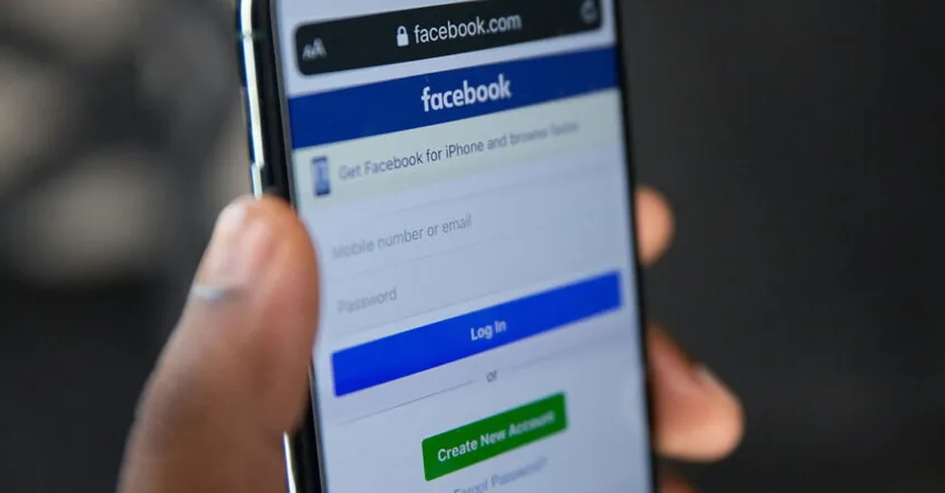 Čovjek koji koristi mobilni telefon za prijavu na Facebook