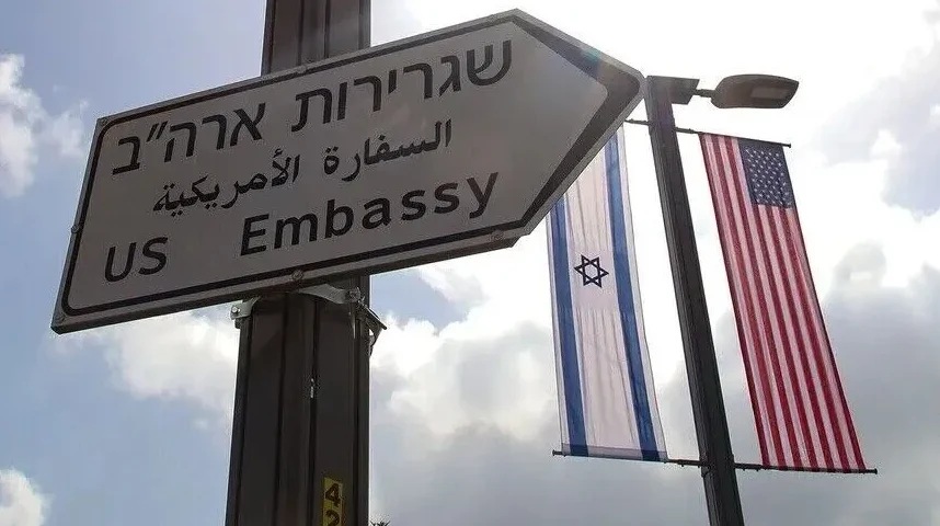 Putokaz prema Američkoj ambasadi pored zastava Izraela i Sjedinjenih Američkih Država.