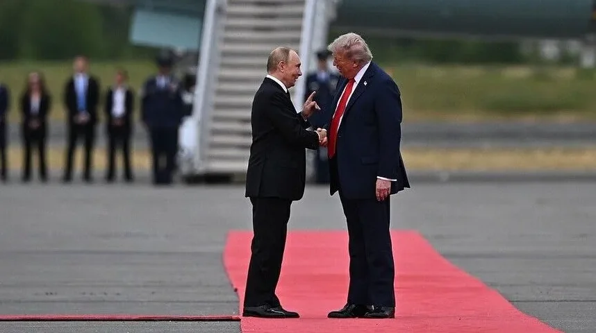 Vladimir Putin i Donald Trump se rukuju na crvenom tepihu.
