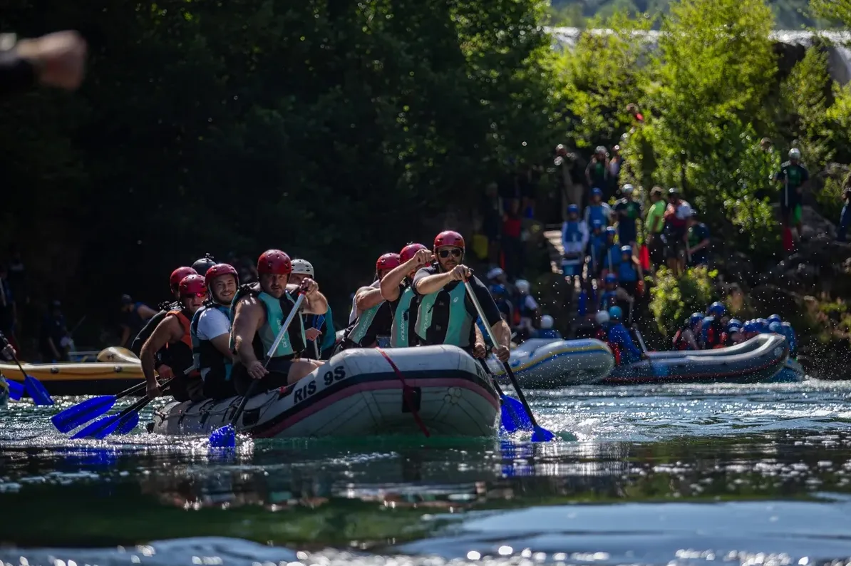 Grupa ljudi na raftingu vesla niz rijeku