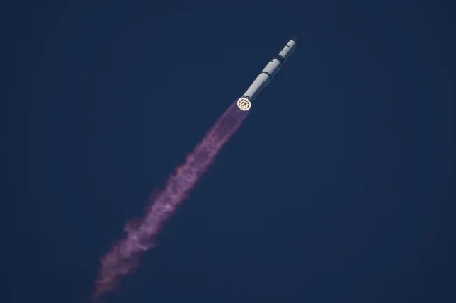 Raketa se uspinje ka nebu ostavljajući za sobom ljubičasti trag dima od sagorijevanja.