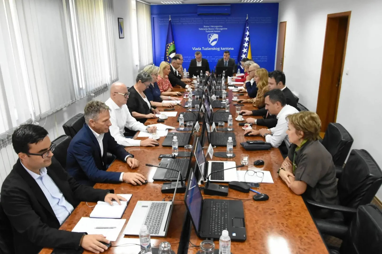 Grupa ljudi na sastanku za velikim stolom
