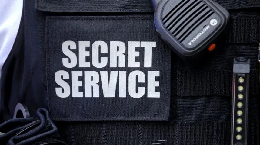 Krupni plan dijela prsluka sa natpisom "SECRET SERVICE", radio veze i okvira za metke.
