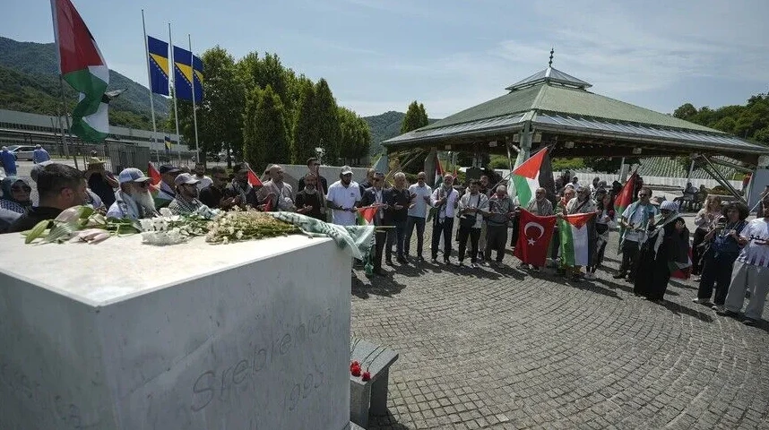 Grupa ljudi drži zastave Palestine i Turske kod spomenika u Srebrenici.