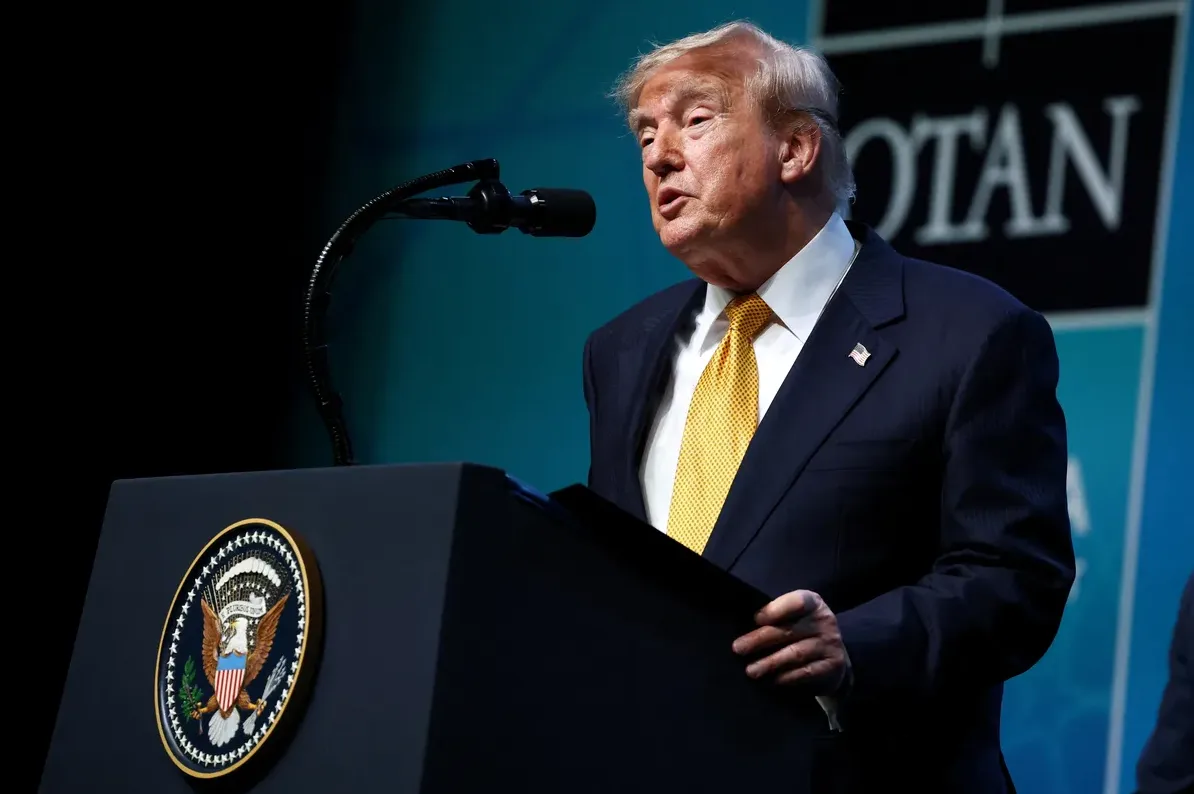 Donald Trump govori sa govornice sa grbom SAD-a i natpisom NATO u pozadini.