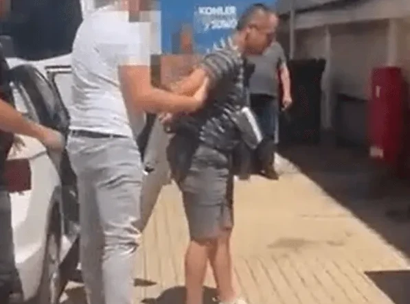 Policajci hapse muškarca na ulici pored bijelog kombija.