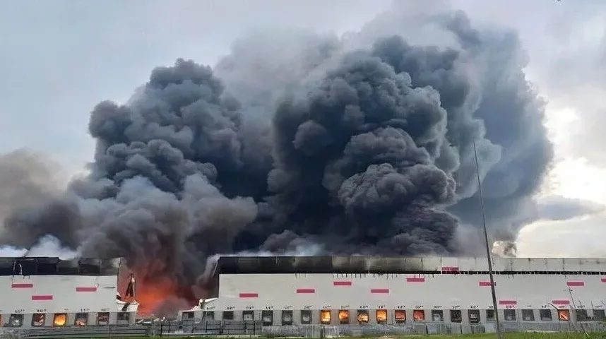 Veliki požar guta skladište, gusti crni dim kulja u nebo.
