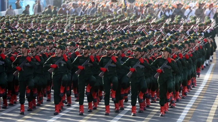 Vojnici iranske armije u zelenim uniformama marširaju sa automatskim puškama.