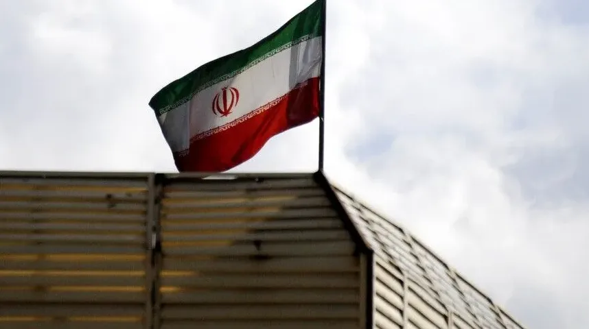 Zastava Islamske Republike Iran vijori se na vjetru iznad vrha građevine sa rebrastom fasadom.