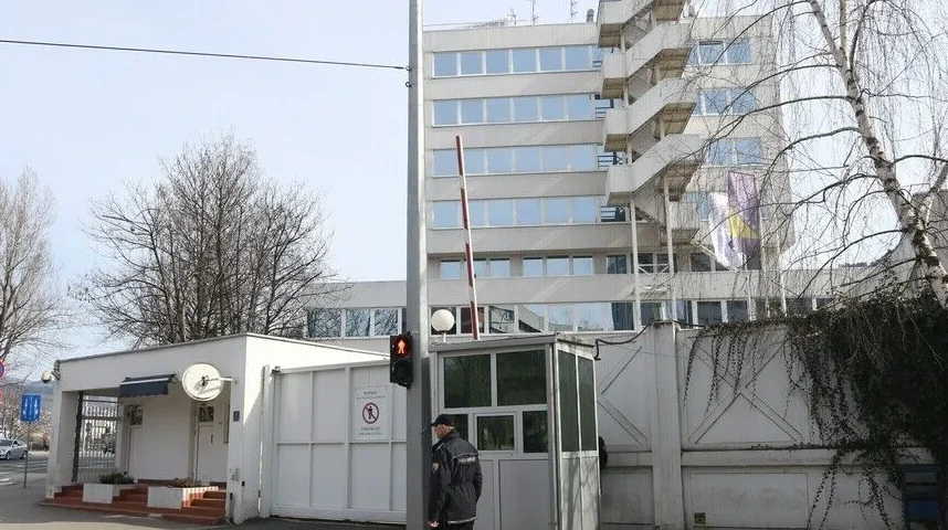 Vanjski pogled na zgradu ambasade sa kontrolnim punktom i zastavom
