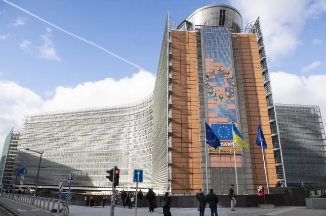 Moderna zgrada Evropske komisije sa zastavama Evropske unije i Ukrajine.
