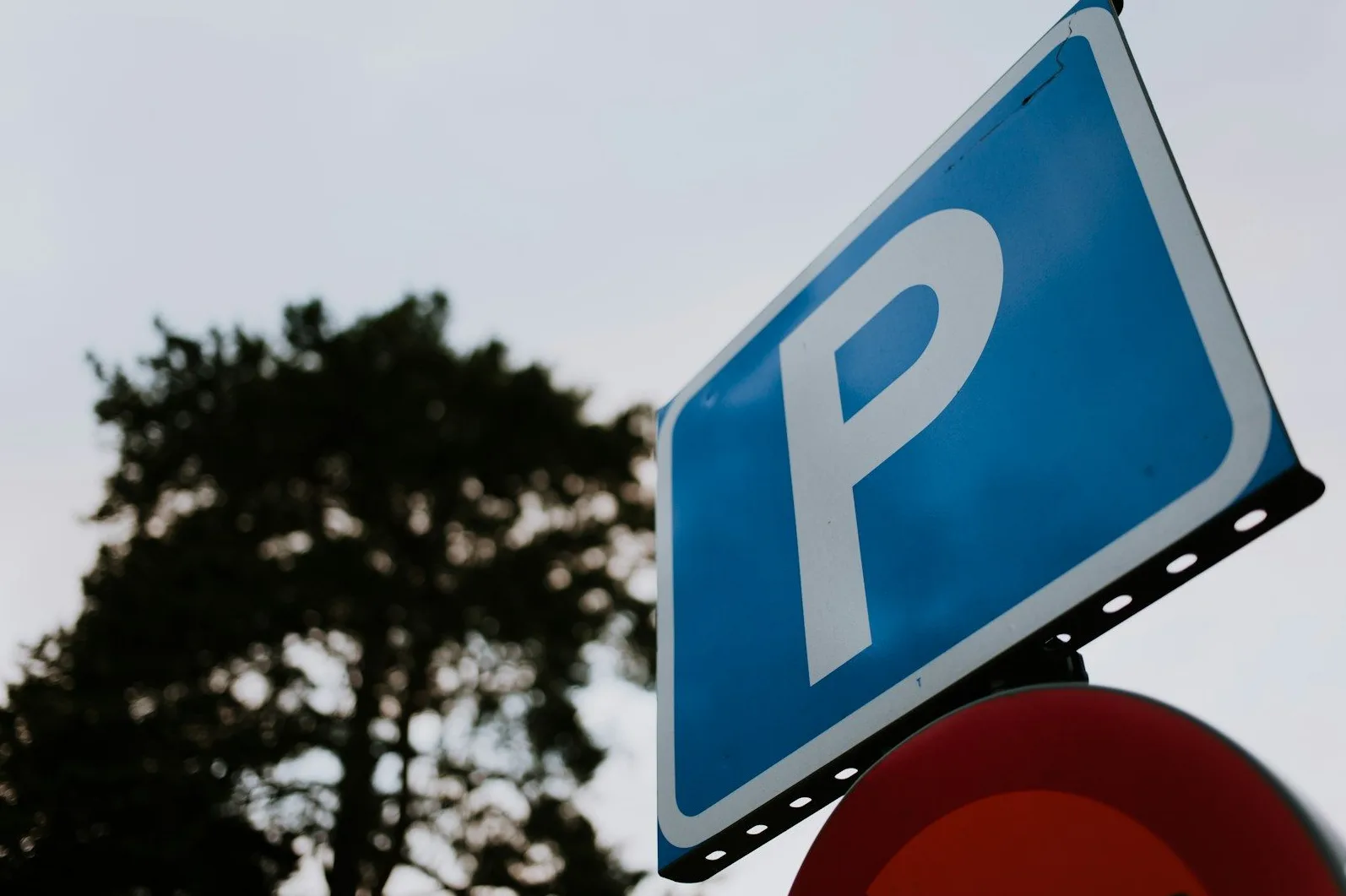 Plavi saobraćajni znak sa bijelim slovom "P" koje označava parking.
