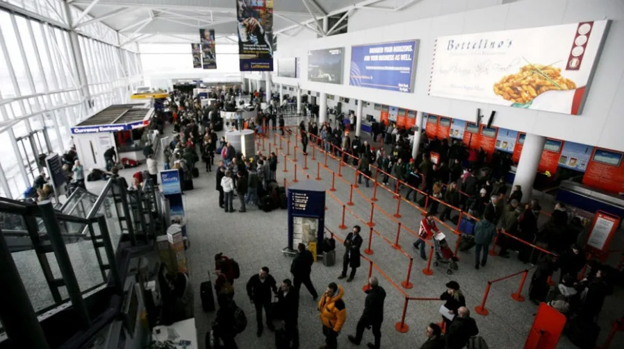 Putnici u dugim redovima čekaju na aerodromu.
