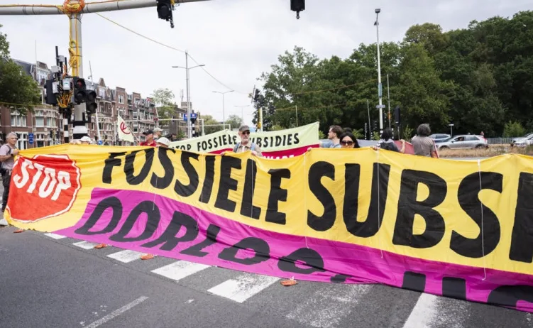 Aktivisti drže transparent "Stop F Fossilne Subvencije"