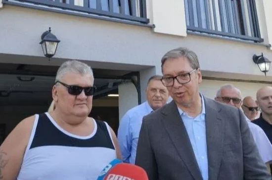 Predsjednik Srbije Aleksandar Vučić razgovara sa građaninom ispred zgrade.