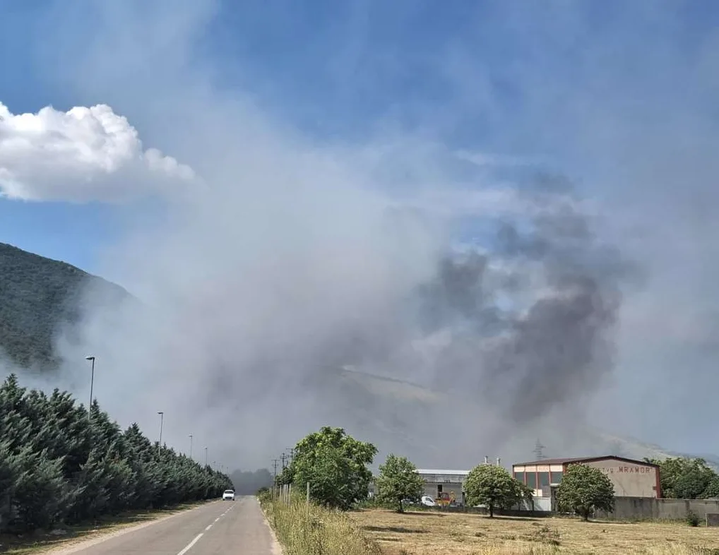 Dim koji se diže iznad planine i obližnjih zgrada