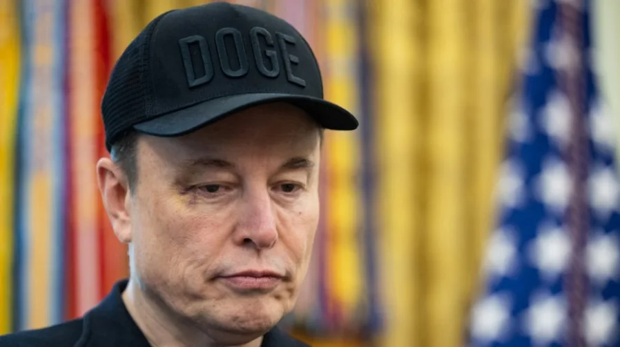 Elon Musk nosi crnu kapu sa natpisom "DOGE"