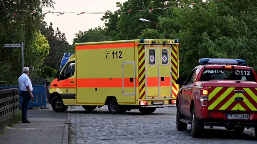 Hitna pomoć sa oznakom 112 i crveno vatrogasno vozilo sa rotacijom i oznakom 112 parkirani na kamenoj ulici.