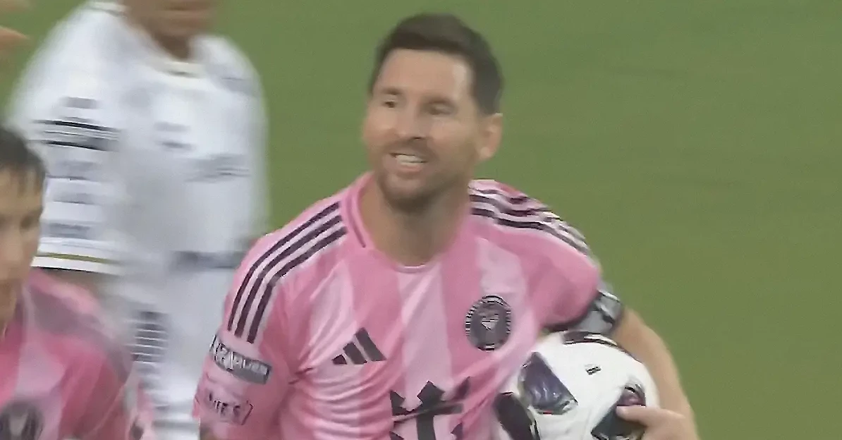 Fudbaler Lionel Messi u ružičastom dresu Inter Miamija drži fudbalsku loptu.