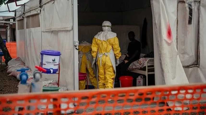 Medicinski radnik u zaštitnom odijelu u šatorskoj bolnici.