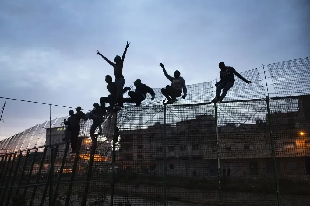 Migranti penju se preko ograde